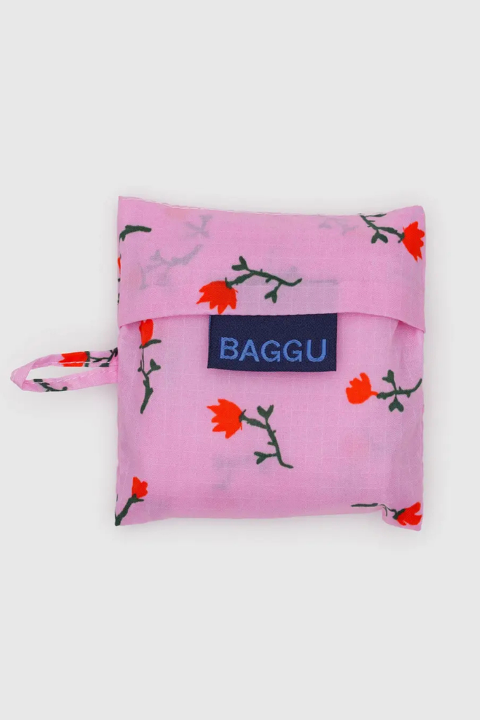Pink reusable bag with floral pattern and 'Baggu' logo on a white background
