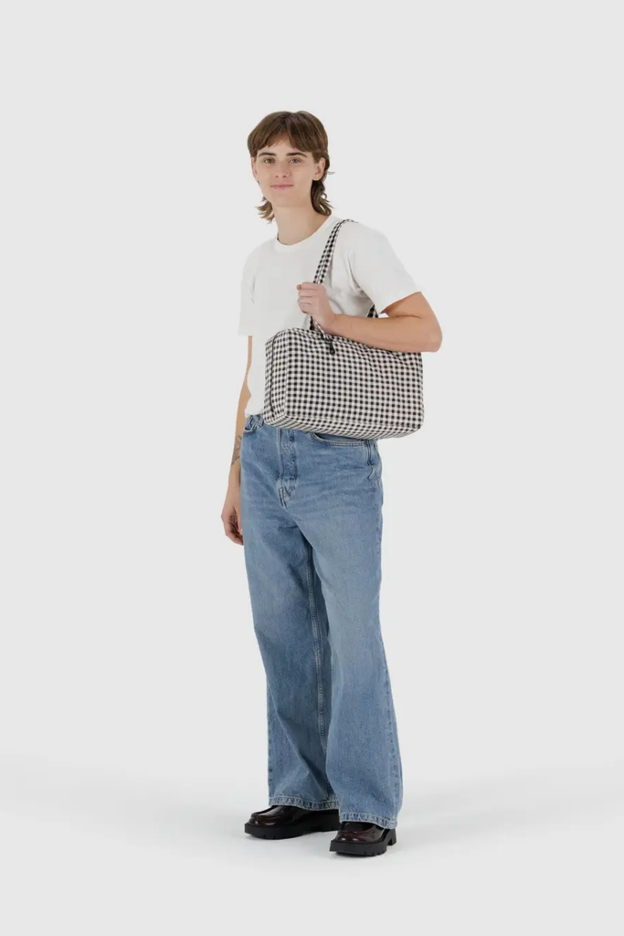 Person holding a checkered bag against a white background