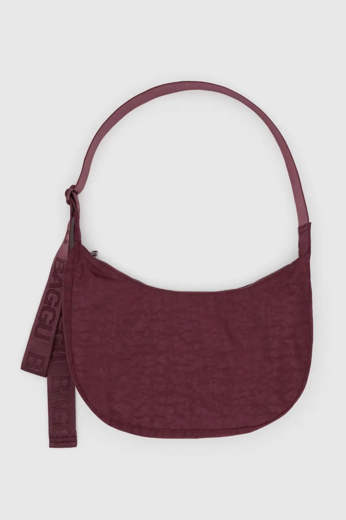 Maroon handbag with a strap on a white background