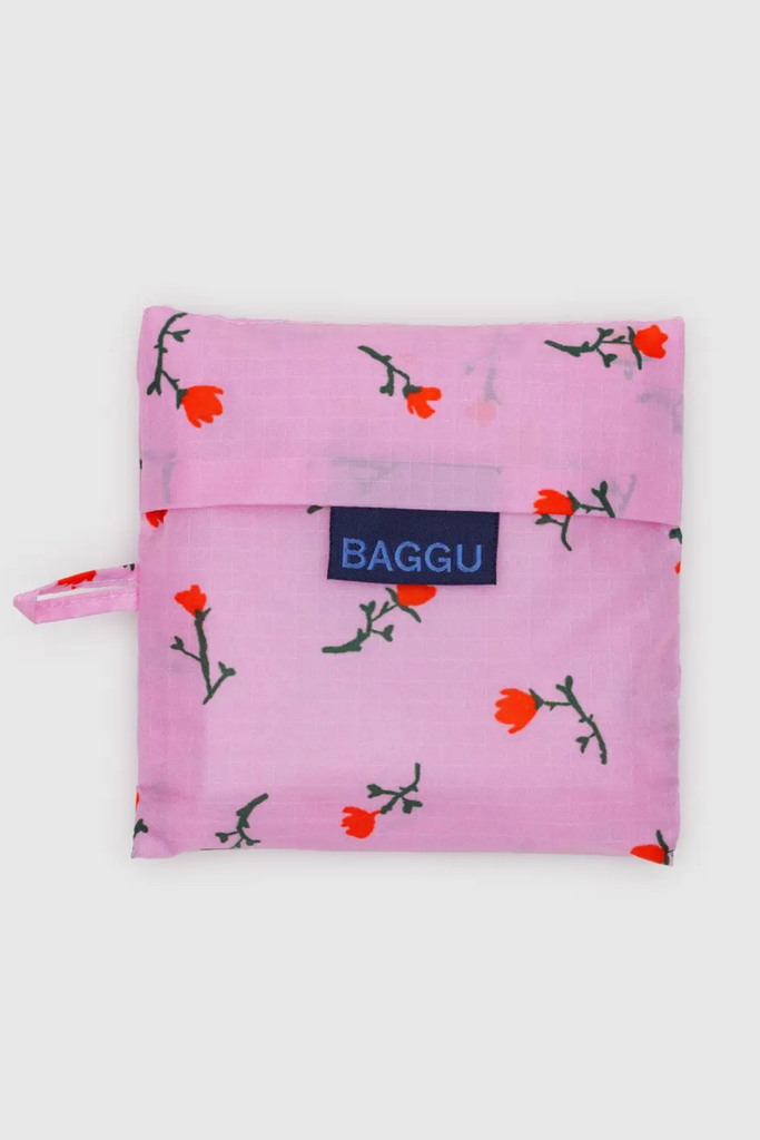 Pink reusable bag with floral pattern and 'Baggu' brand label on a white background