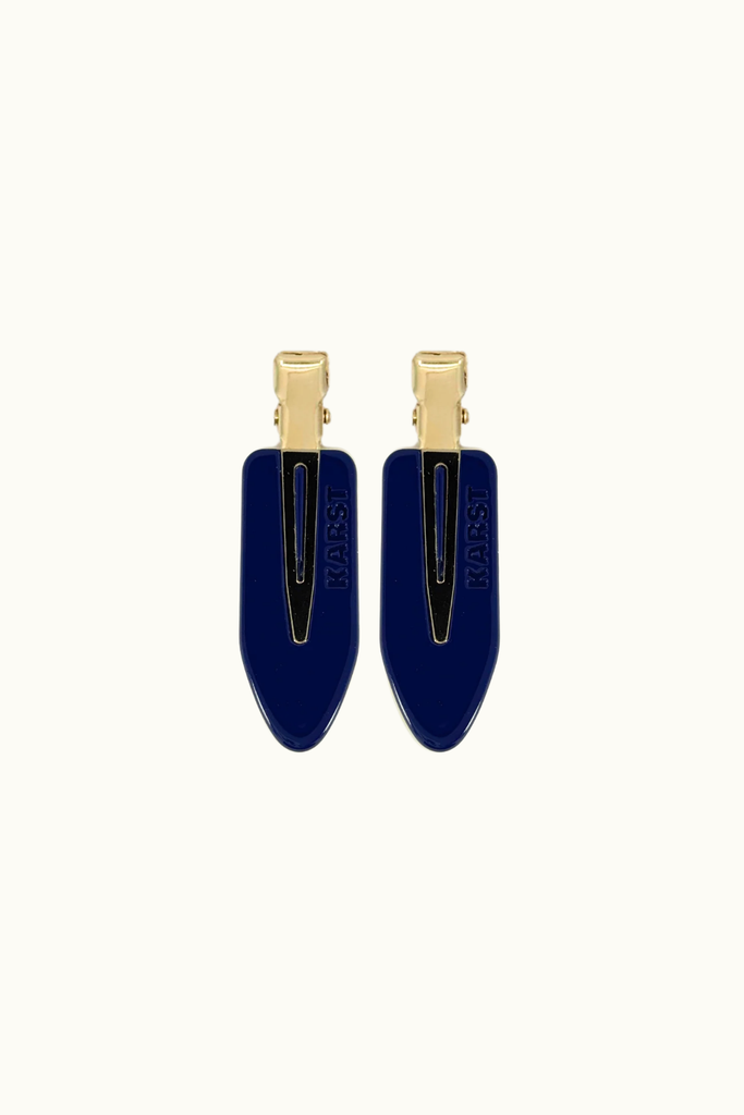 Navy blue hair clips with gold accents on a white background