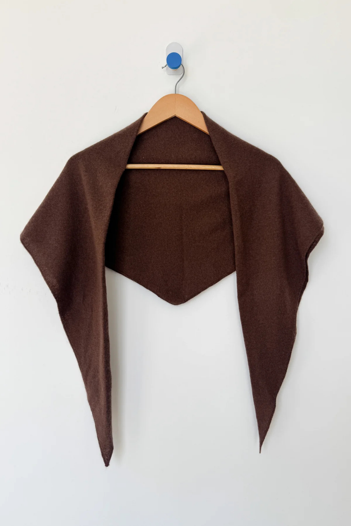 Brown shawl draped over a wooden hanger against a white background