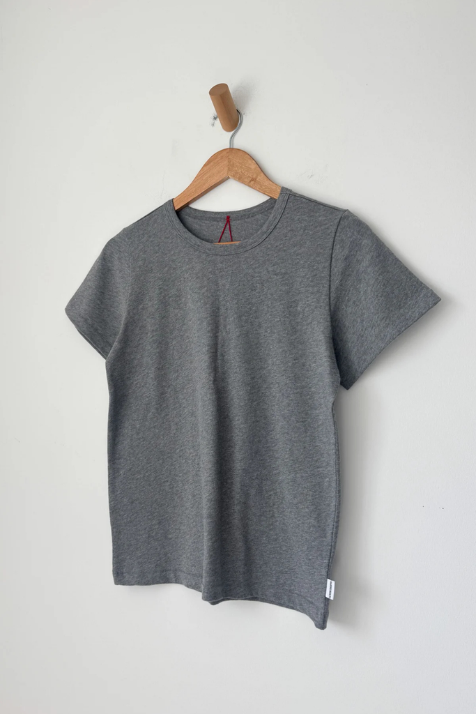 Gray t-shirt on a wooden hanger against a white background