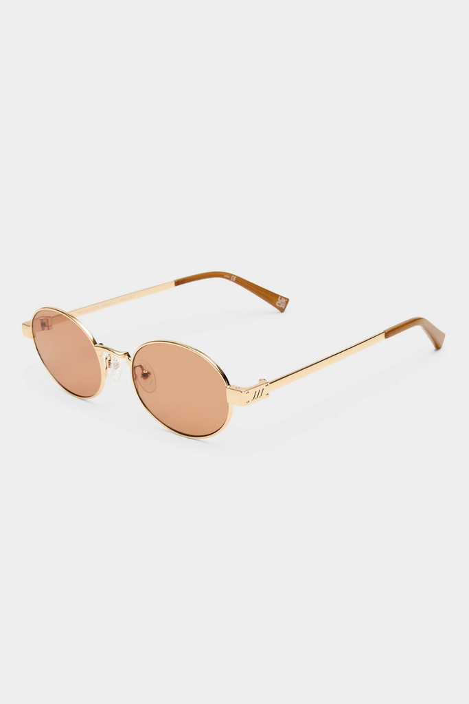Gold-framed sunglasses with rose gold lenses on a white background