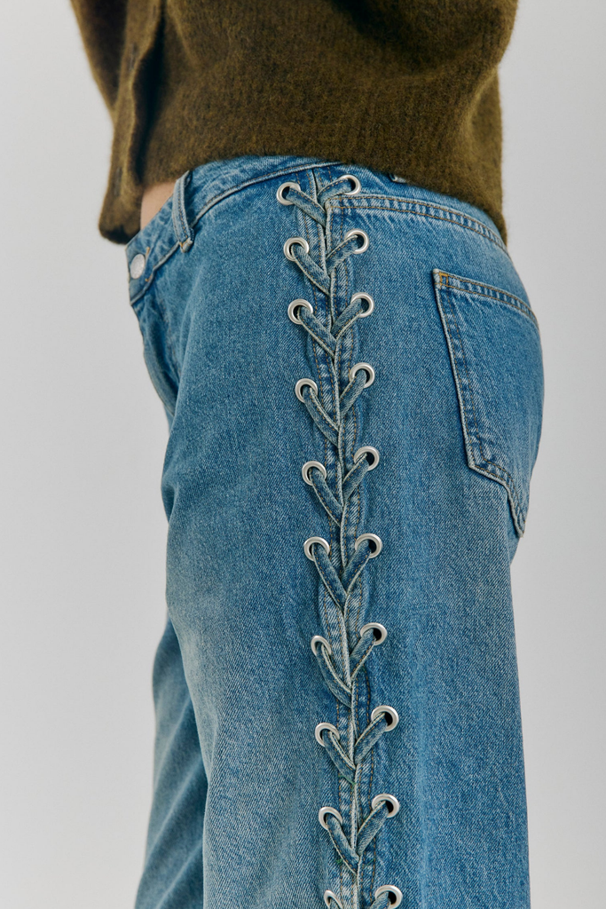 Blue jeans with decorative stitching on a plain background